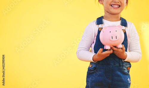 Girl kid, piggy bank and saving in studio with smile, mockup space and excited by yellow background. Young female child, money box and start investment for promo, financial knowledge or future goal