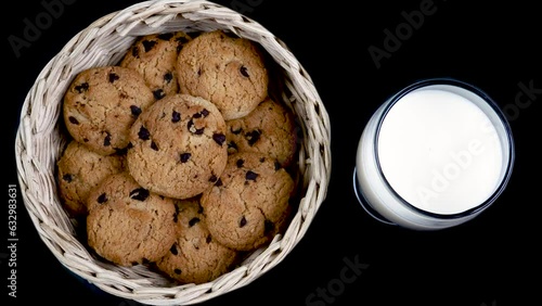 Fresh Milk and Chocolate chip cookies in a bamboo basket isolated on black background