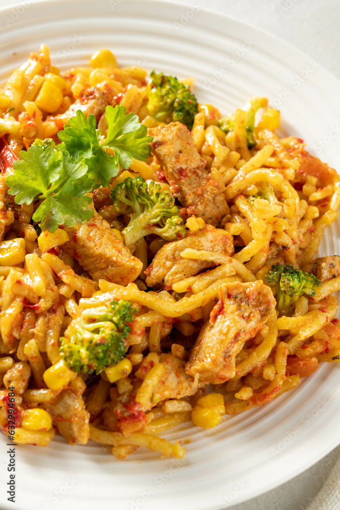 Stir-fried egg noodles with chicken breast in a white plate. Stir-fried egg noodles with chicken breast in a white plate.