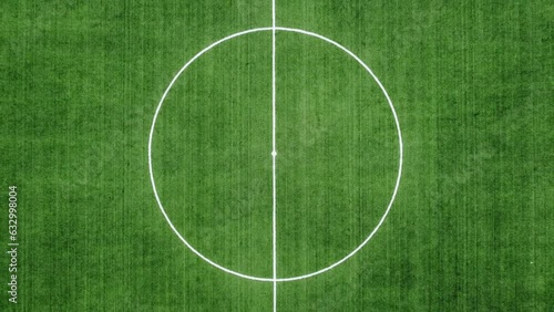 4k aerial top view of empty new football field with running tracks - zoom out from centre of the field