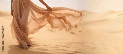 Woman in a long dress walking in the desert with flowing fabric in the wind