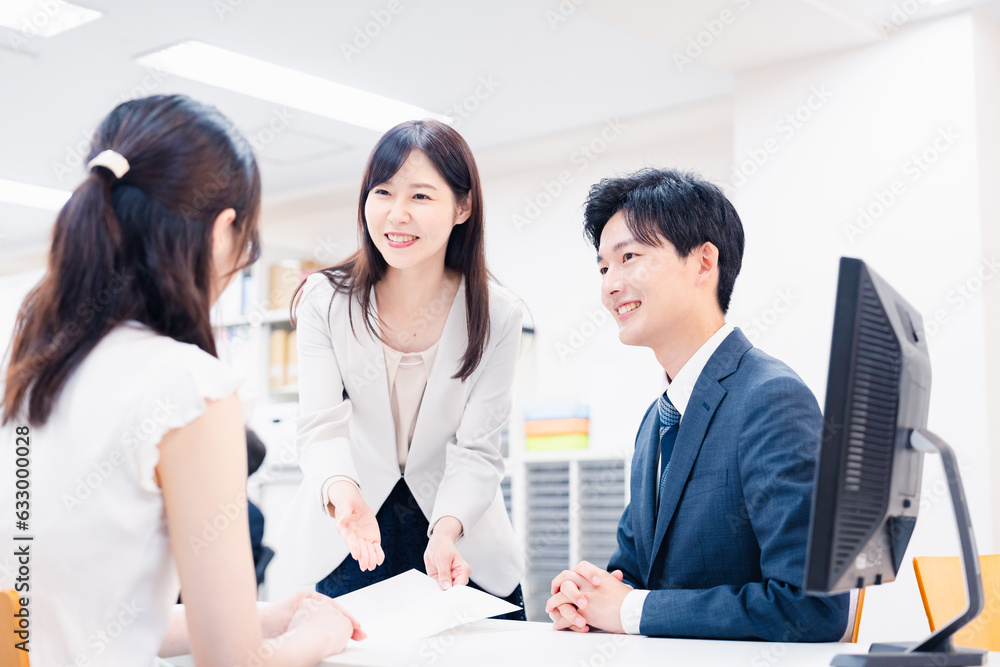窓口でにこやかに対応をするスタッフ 窓口でにこやかに対応をするスタッフ