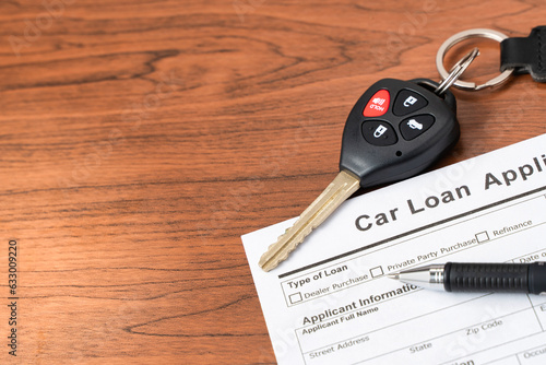 Closeup car key on car loan application form. Car loan or finance concept. Automobile business.