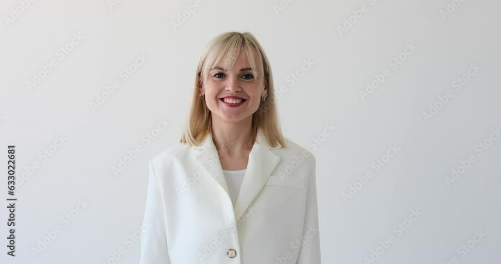 A Caucasian woman on a white background is seen making a hand gesture that indicates Call Me. She extends her thumb and pinky finger while holding the other fingers down, forming the universal sign A Caucasian woman on a white background is seen making a hand gesture that indicates Call Me. She extends her thumb and pinky finger while holding the other fingers down, forming the universal sign