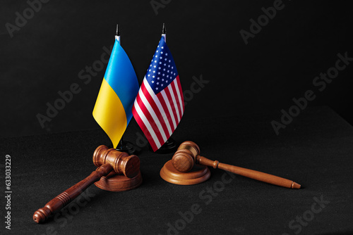 Two judge's gavels with USA flag and flag of Ukraine on black background