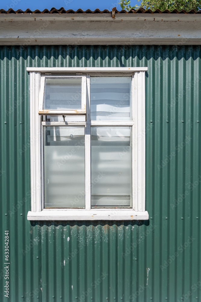 Fototapeta premium Green building wall with a window on a sunny day, taken in Iceland, downtown Reykjavik