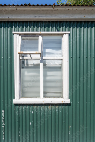 Green building wall with a window on a sunny day, taken in Iceland, downtown Reykjavik © MelissaMN
