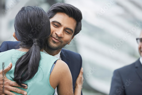 Businesspeople greeting each other with kiss on cheek