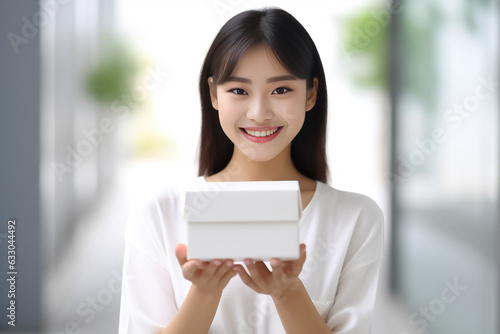 In front of view portrait of woman wearing T-shirt standing with carton box and looking at camera with sweet smile isolated on white gray background. Generative AI.