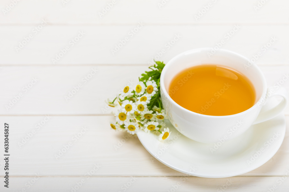 Chamomile tea on a white table. Delicious tonic, soothing and relaxing chamomile tea with chamomile flowers, honey and lemon. Herbal tea for immunity. Close-up.Place for text.Copy space. Chamomile tea on a white table. Delicious tonic, soothing and relaxing chamomile tea with chamomile flowers, honey and lemon. Herbal tea for immunity. Close-up.Place for text.Copy space.