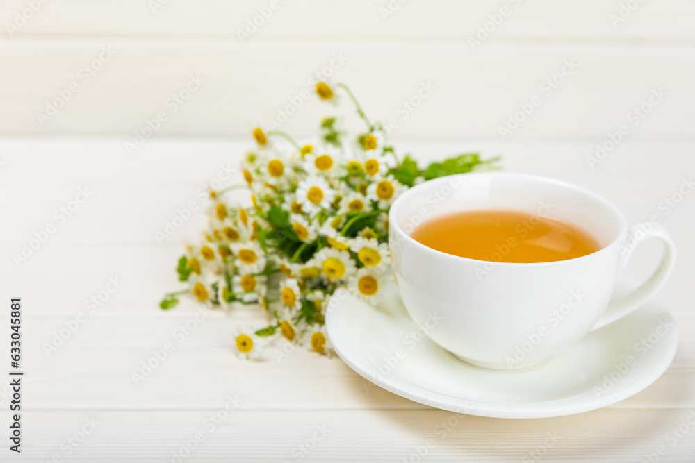Chamomile tea on a white table. Delicious tonic, soothing and relaxing chamomile tea with chamomile flowers, honey and lemon. Herbal tea for immunity. Close-up.Place for text.Copy space. Chamomile tea on a white table. Delicious tonic, soothing and relaxing chamomile tea with chamomile flowers, honey and lemon. Herbal tea for immunity. Close-up.Place for text.Copy space.