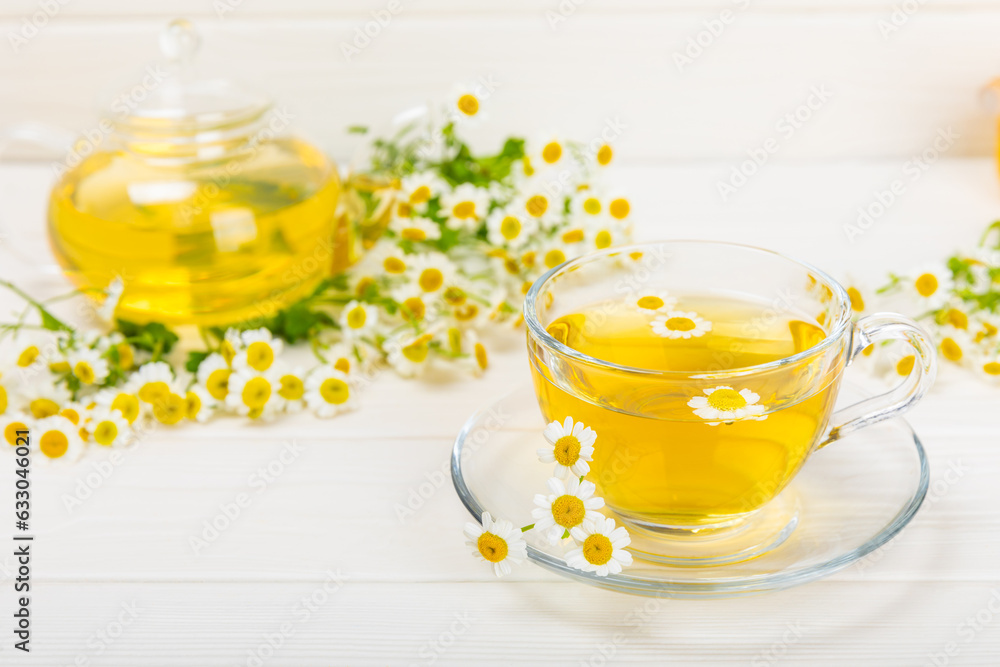 Chamomile tea on a white table. Delicious tonic, soothing and relaxing chamomile tea with chamomile flowers, honey and lemon. Herbal tea for immunity. Close-up.Place for text.Copy space. Chamomile tea on a white table. Delicious tonic, soothing and relaxing chamomile tea with chamomile flowers, honey and lemon. Herbal tea for immunity. Close-up.Place for text.Copy space.