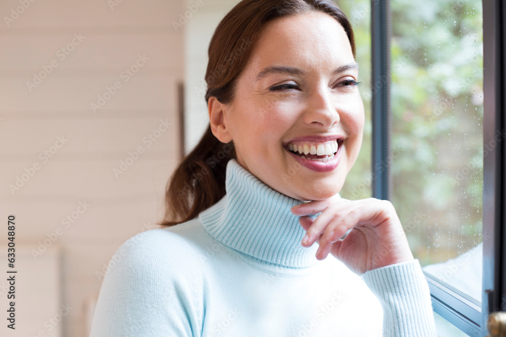 Mid adult woman standing at window. Mid adult woman standing at window.