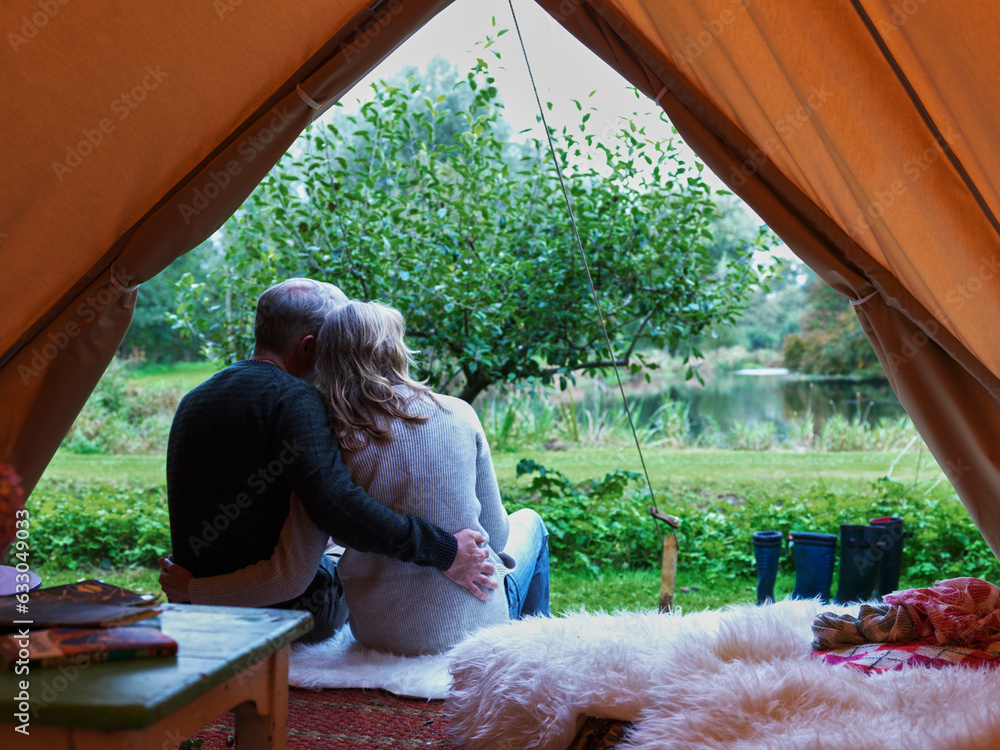 © Connect Images - Mature married couple sitting in tent together.
