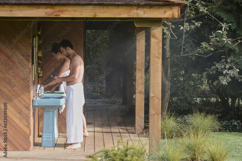 Young couple brushing their teeth at outdoor sink. Young couple brushing their teeth at outdoor sink.