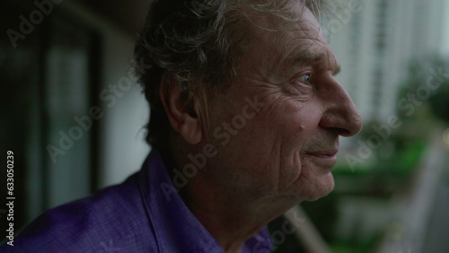 Tranquil older man looking around from high above in apartment balcony © Marco