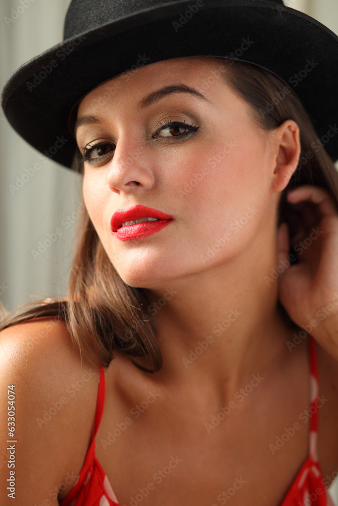 Portrait of young woman wearing red lipstick and bowler hat Portrait of young woman wearing red lipstick and bowler hat