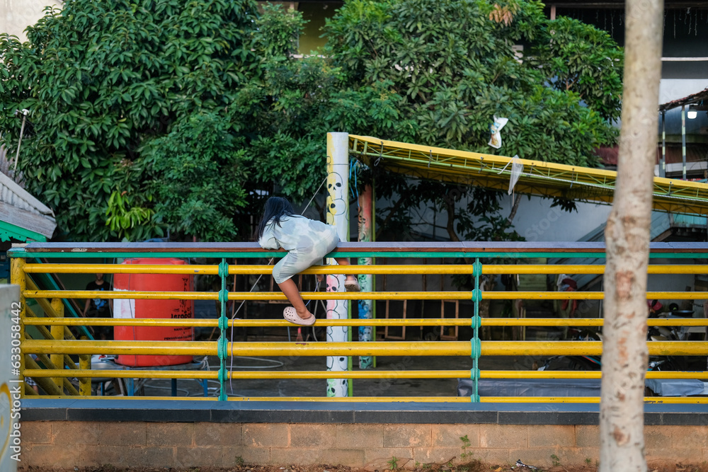 a child climbs the road guardrail, parents must always supervise their child's activities when they go out of the house