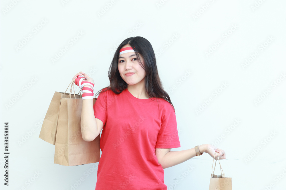 portrait of beautiful asian woman wearing red outfit celebrating Indonesia independence day by gesturing carrying lots of shopping bags with happy expression portrait of beautiful asian woman wearing red outfit celebrating Indonesia independence day by gesturing carrying lots of shopping bags with happy expression