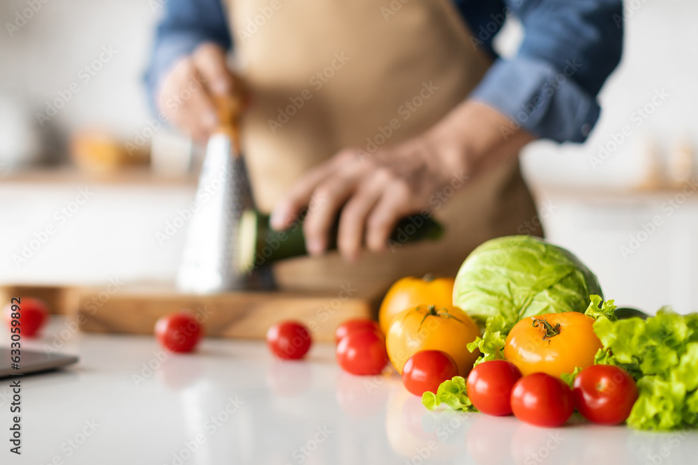 Unrecognizable Man In Apron Cooking Vegetable Meal In Kitchen