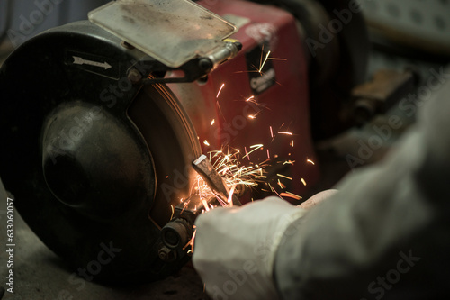 Hand of mechanic grinding metal photo