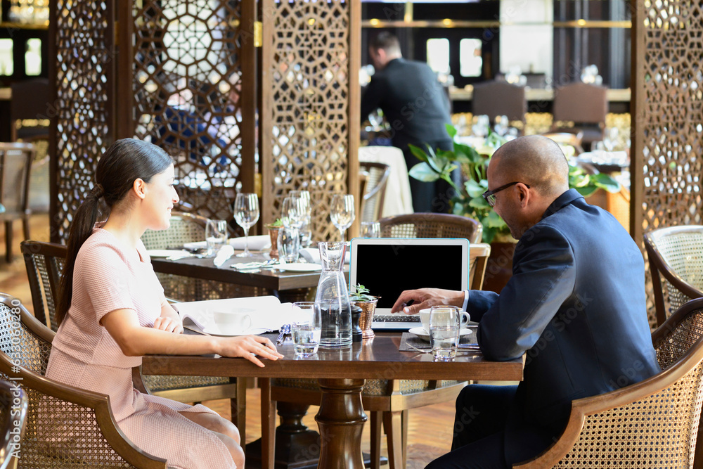 Businesspeople using laptop during meeting at cafe Businesspeople using laptop during meeting at cafe