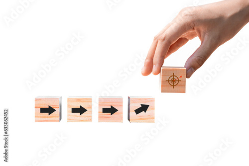 Arrow leading point to target icon on wooden blocks with businessman hand as a step towards the goal. Business ideas for a successful growth process.PNG