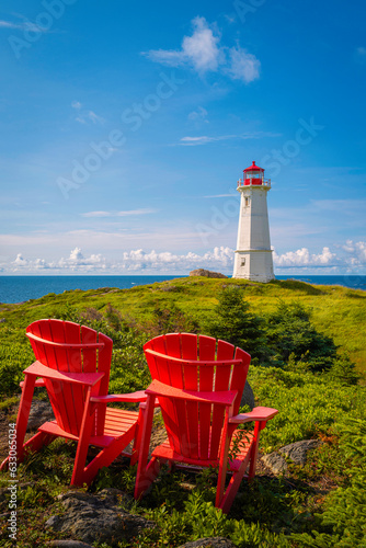 Papier peint Two Adirondack benches or Muskoka chairs with a lighthouse in Louisbourg on Cape