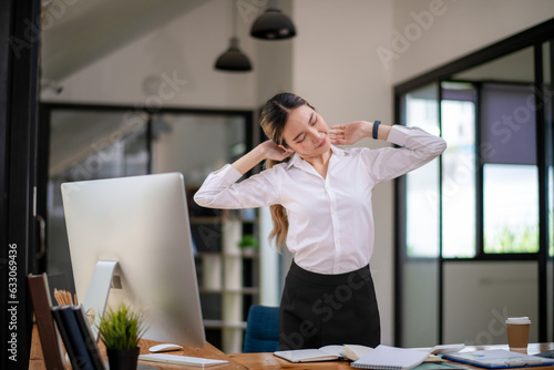 Businesswoman stretching lazy at the desk to relax while working in the office. photo