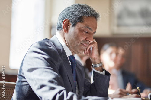 Businessman writing notes during meeting photo