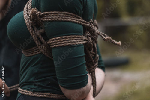 tied up woman in green body and black tights with a natural rope japanese art of aeshetic shibari bandage kinbaku
