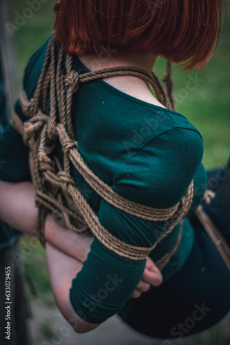 tied up woman in green body and black tights with a natural rope japanese art of aeshetic shibari bandage kinbaku
