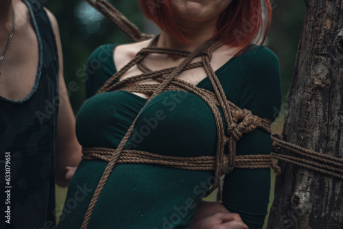 breast of beautiful redhead woman in green body tied with shibari rope Kinbaku japanese bandage
