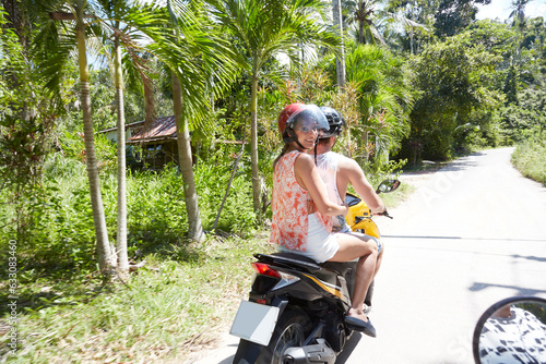 Young man and woman riding moped photo