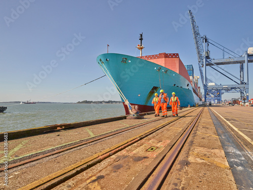 Dock workers and cargo ship at Port of Felixstowe, England