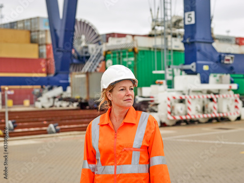 Portrait of dock worder standing infron of crane loading cargo to trainline photo