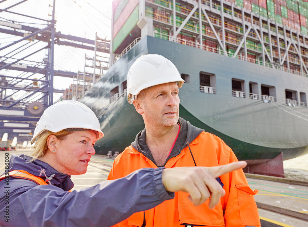 Portrait of docks worker and manager talking infront of cargo ship and cranes Portrait of docks worker and manager talking infront of cargo ship and cranes