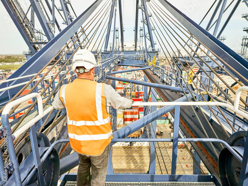 Dock worker by railing of crane