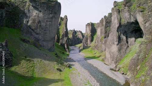 Rugged lush Fjadrargljufur canyon with Fjadra river flowing in summer at Iceland photo