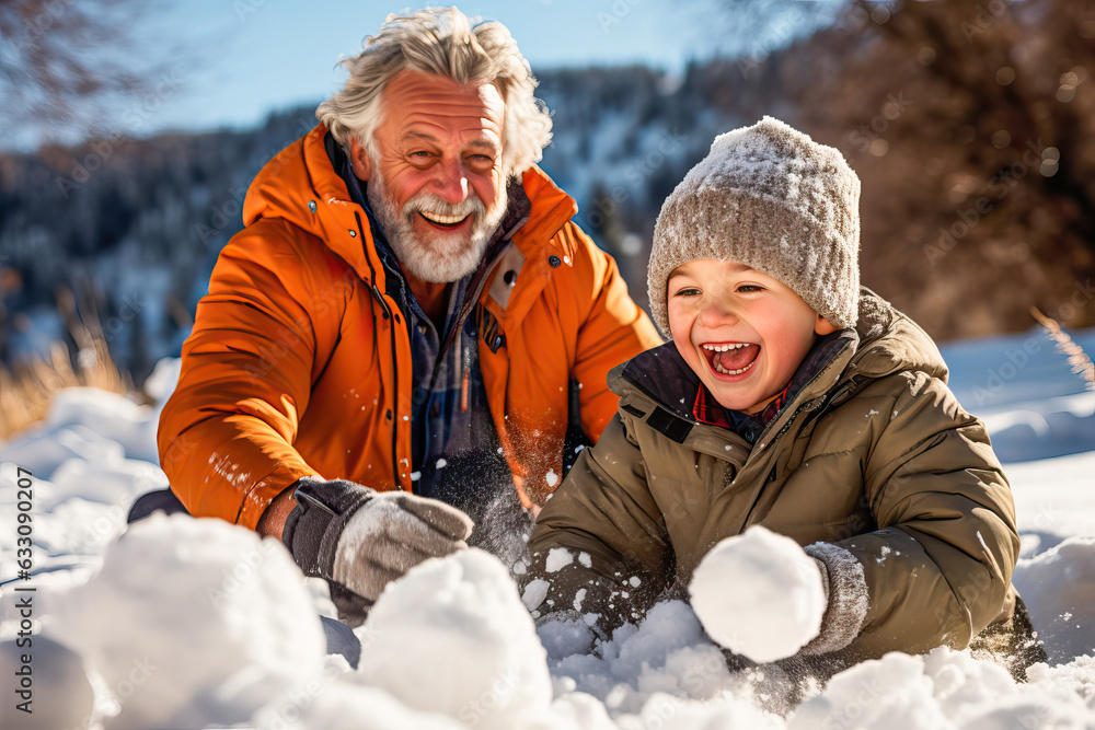 Grandfather and grandson making a snowman in a snowy field - obrazy, fototapety, plakaty 
