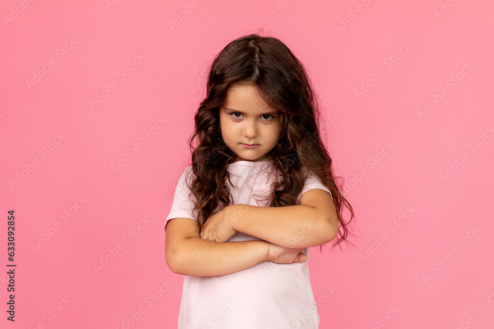 Negative human emotions, reactions and feelings. Isolated shot of moody displeased angry little girl crossing arms on her chest, pouting lips, having offended facial expression, being capricious Negative human emotions, reactions and feelings. Isolated shot of moody displeased angry little girl crossing arms on her chest, pouting lips, having offended facial expression, being capricious