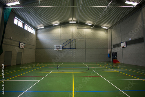 Sports gymnasium  with basketball hoop court and Florescent lighting 