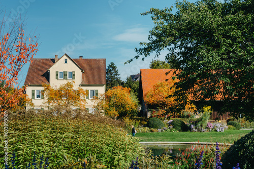 House with nice garden in fall. Flowers in the City Park of Bietigheim-Bissingen, Baden-Wuerttemberg, Germany, Europe. Autumn Park and house, nobody, bush and grenery