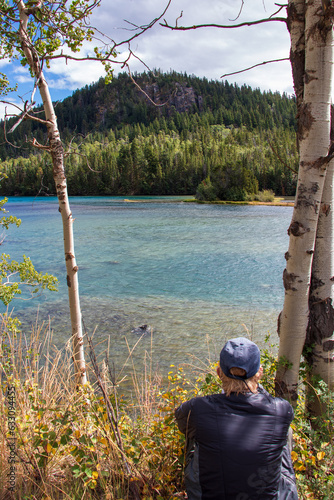 A man resting by a riverbank and contemplating life.