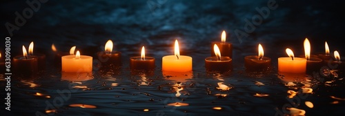 Burning candles on dark background, peaceful scene with copy space, extra wide.