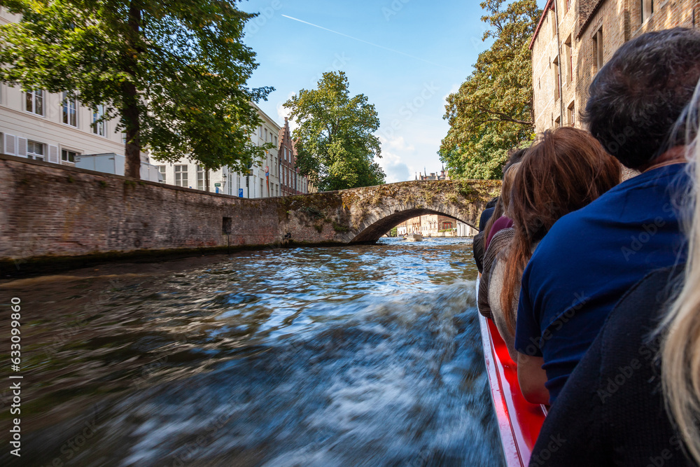 Fototapeta premium Tourists on a sight seeing boat trip in Bruges Belgium on the Brugge Zeebrugge Canal