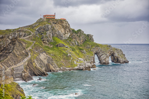 view of gaztelugatxe island with cloudy dramatic sky and stormy weather