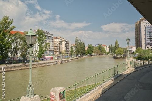 Photography on a beautiful sunny day, people walk along the walls of the danube promenade, which are painted with graffiti
