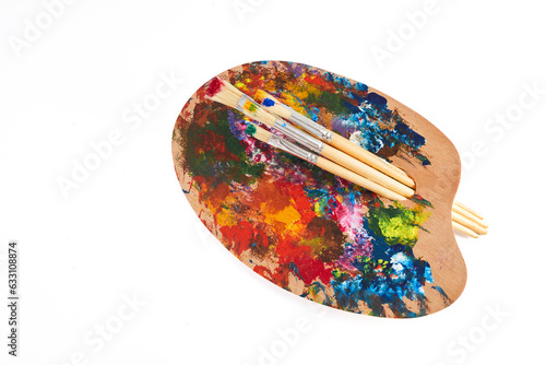 Wooden art palette with brushes isolated on white background.