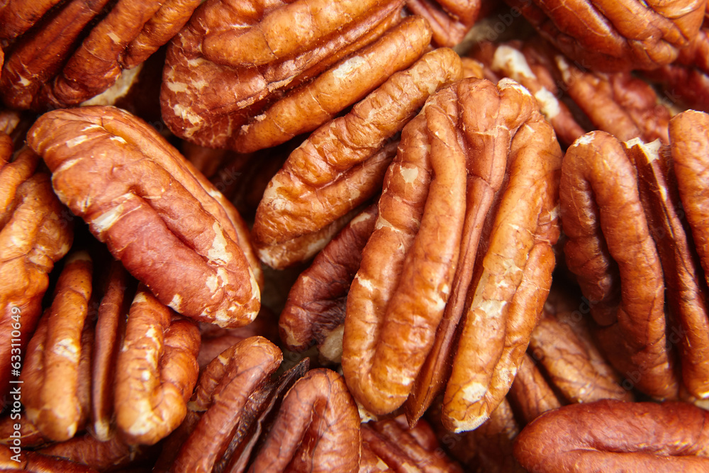 Pecan nuts kernel texture background closeup. Heap of peeled pecan halves. Macro view captures a heap of halved pecans Pecan nuts kernel texture background closeup. Heap of peeled pecan halves. Macro view captures a heap of halved pecans